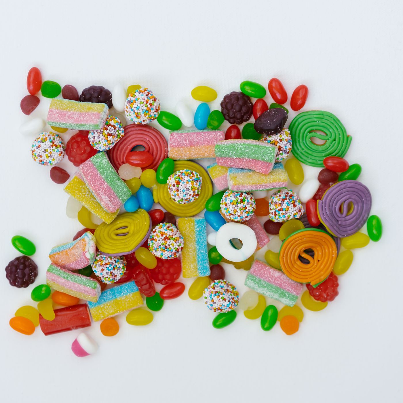 Assorted colorful candies arranged on a white surface