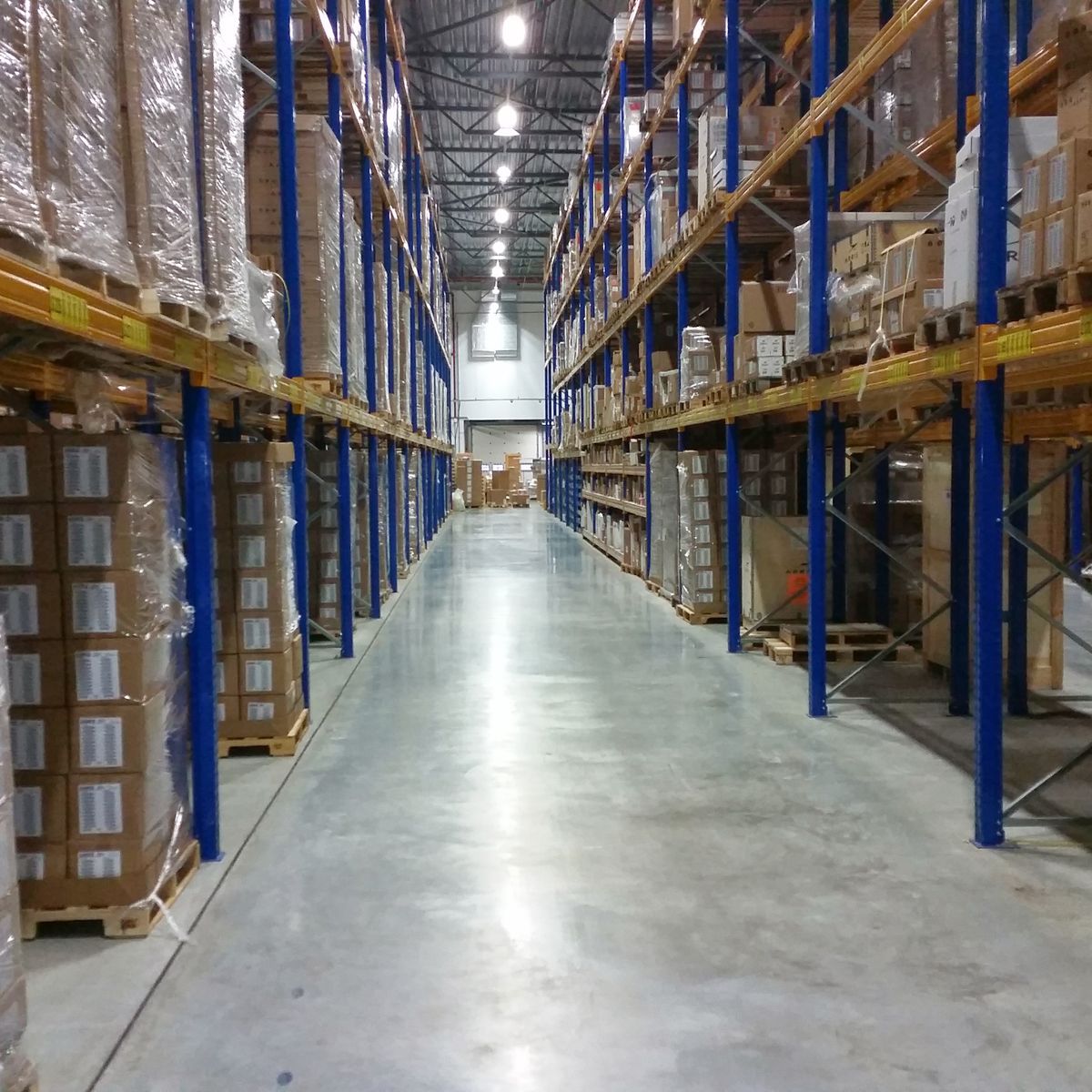 Warehouse aisle lined with stacked cases on pallet racking