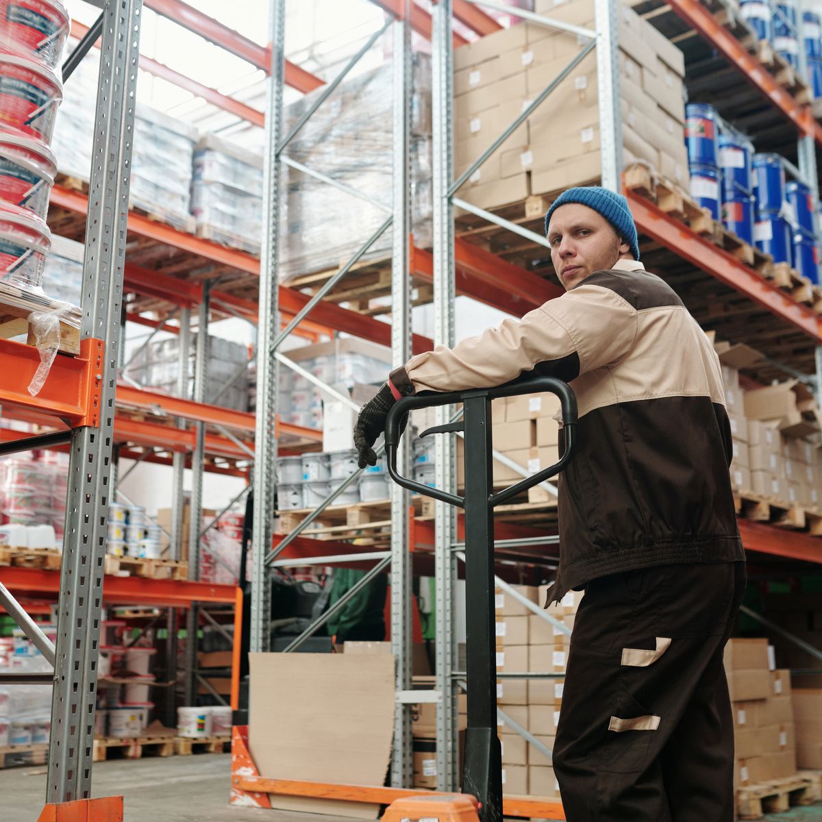 Warehouse worker moving a pallet with a pallet jack